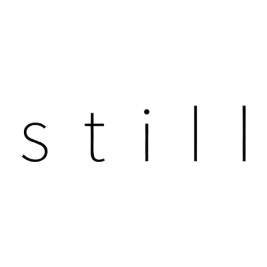Minimal fine line tattoo lettering reading still in thin sans serif